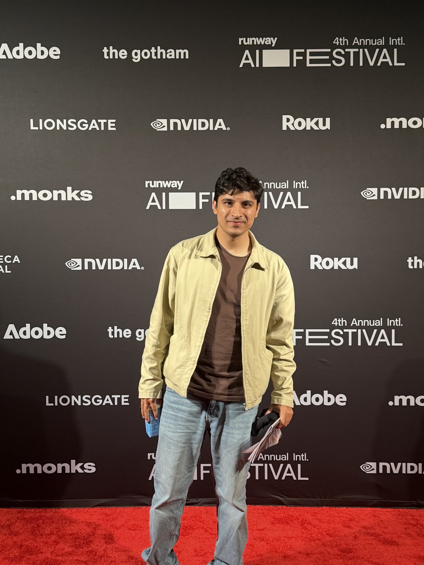 Javishth Chabria on the Runway AI Film Festival step-and-repeat, with sponsor wordmarks including Adobe, Lionsgate, NVIDIA, Roku, .monks and The Gotham on the backdrop.